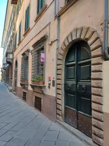a building with a door on the side of a street at La Colonna Historic Centre in Lucca