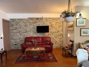 a living room with a red couch and a brick wall at B&B Luxury in Lecce