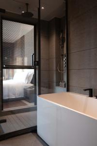 a bath tub in a bathroom with a bedroom at Shanghai Qiuzhu Hotel - Near Shanghai Disney Resort & Wildlife Park - Free Buffet Breakfast - Pick-up Service for Disneyland, PVG Airport, Wildlife Park & Xinchang Metro Station in Shanghai +67 photos