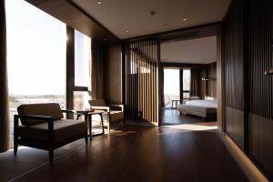 a bedroom with a bed and a chair and a table at Shanghai Qiuzhu Hotel - Near Shanghai Disney Resort & Wildlife Park - Free Buffet Breakfast - Pick-up Service for Disneyland, PVG Airport, Wildlife Park & Xinchang Metro Station in Shanghai