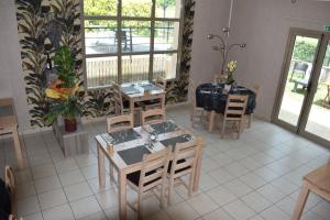 a dining room with tables and chairs and windows at Carpe Diem 3 in Goutrens
