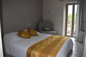 a bedroom with a bed with yellow pillows and a chair at Carpe Diem 3 in Goutrens