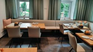 a dining room with tables and chairs and windows at Haslgut in Fuschl am See