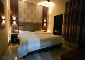 a bedroom with a large white bed in a room at Hotel Blessing Inn in Jalandhar +20 photos