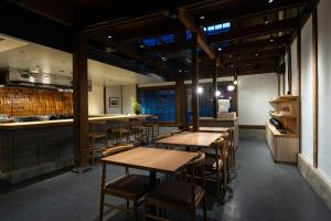a restaurant with wooden tables and chairs and a counter at 中尾甚六Hotel in Karatsu