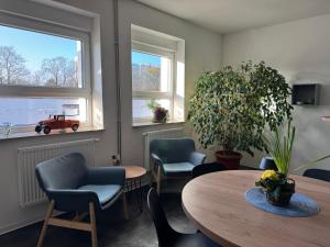 a waiting room with a table and chairs and a car in the window at City Inn Schwedt in Schwedt