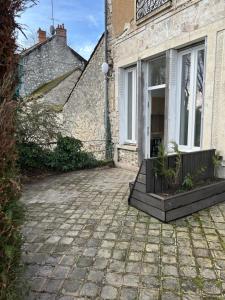 eine gemauerte Terrasse vor einem Gebäude in der Unterkunft L écluse in Nemours