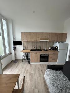 eine Küche mit Holzschränken und einer Arbeitsplatte in der Unterkunft L écluse in Nemours