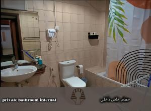 a bathroom with a sink and a toilet and a tub at AlWasl Guesthouse by PHM in Dubai