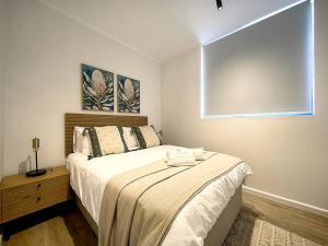 a bedroom with a bed and a large window at Luxury Apartment Unit 101 in George