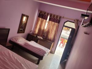 a small room with two beds and a window at New Samrat Hotel & Restaurant in Srīnagar