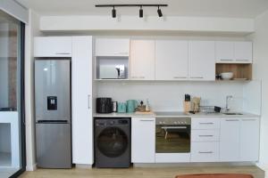 a kitchen with white cabinets and a dishwasher at Luxury Apartment Unit 101 in George