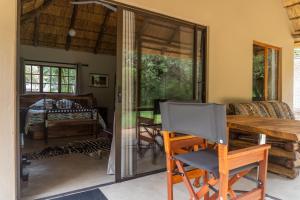 a dining room with a table and glass doors at Shumba Safari Bush Camp in Hoedspruit
