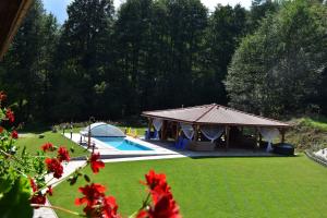 a gazebo with a tent and a swimming pool at Penzión na Ráztočnom in Klenovec