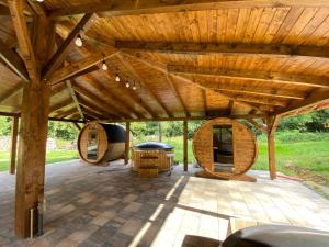 an outdoor patio with a wooden roof and a table at Penzión na Ráztočnom in Klenovec
