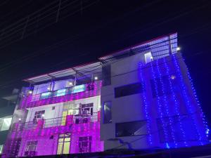 a building with blue and purple lights on it at New Samrat Hotel & Restaurant in Srīnagar +27 photos