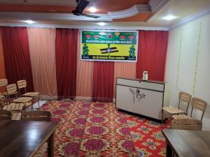 a conference room with a stage and chairs and a podium at New Samrat Hotel & Restaurant in Srīnagar