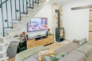 a living room with a couch and a tv at Vadvirág 5 by DunaVibe in Baja +14 photos
