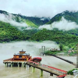 a bridge on a river next to a mountain at New Samrat Hotel & Restaurant in Srīnagar