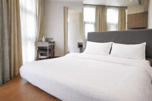 a bedroom with a large white bed with white pillows at Amrise Hotel Kitchener, Check In 9PM, Check Out 8AM in Singapore +23 photos