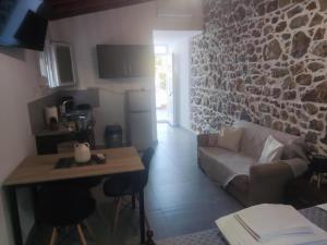 a living room with a couch and a stone wall at Markos House 2 in Kalymnos