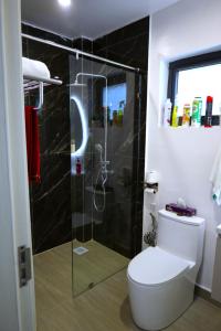 a bathroom with a toilet and a glass shower at GBSL Grand Villa in Nairobi +8 photos