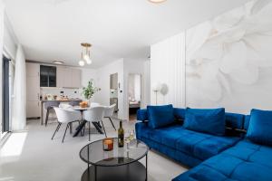 a living room with a blue couch and a table at Euphoria Animar & Tiema in Draga Bašćanska