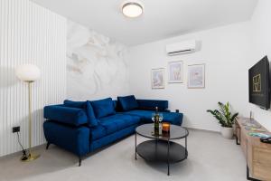 a living room with a blue couch and a table at Euphoria Animar & Tiema in Draga Bašćanska