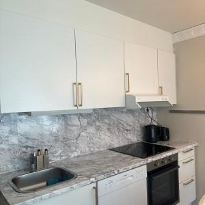 a kitchen with white cabinets and a sink at Private room central in Oslo