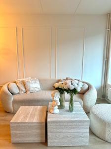 a living room with a couch and a vase of flowers at Private room central in Oslo