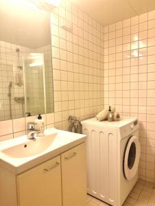a bathroom with a sink and a washing machine at Private room central in Oslo