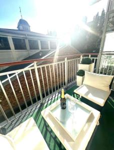 a balcony with a table and a bottle of wine at Private room central in Oslo