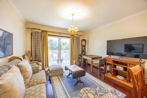 a living room with a couch and a desk and a television at Ocean Lido in Funchal