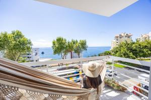 a woman in a hammock on a balcony overlooking the ocean at Ocean Lido in Funchal