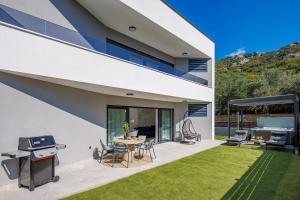 a backyard of a house with a table and chairs at Euphoria Animar & Tiema in Draga Bašćanska