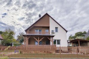a house with a wooden fence in front of it at Vadvirág 5 by DunaVibe in Baja