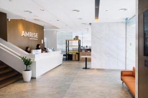 a lobby of an office with two people sitting at a counter at Amrise Hotel Kitchener in Singapore