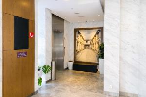 a hallway with a painting of a building at Amrise Hotel Kitchener in Singapore