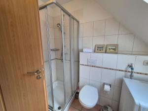 a bathroom with a shower and a toilet and a sink at Atlantik-Kolk 30 in Norddeich +6 photos