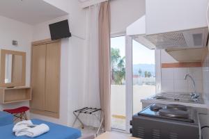a small kitchen with a stove and a balcony at Achilleas Hotel Apartments in Kos