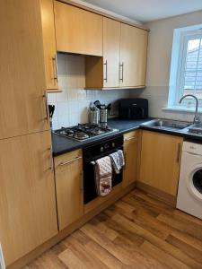 a small kitchen with a stove and a sink at Warm, Sleeps 6, Bathroom, Beaches Shops Cafes Bars Pier, Central Ryde in Ryde