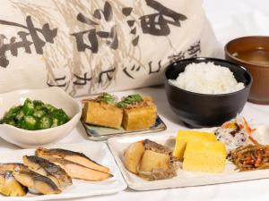 a table with plates of food and a bowl of rice at Court Hotel Niigata in Niigata
