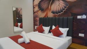 una camera da letto con un letto con cuscini rossi e bianchi di Hanee Comforts a Chikmagalūr