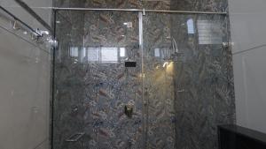 una doccia con porta in vetro in un bagno di Hanee Comforts a Chikmagalūr