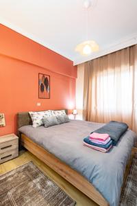 a bedroom with orange walls and a large bed at Elena's House in Polístilon