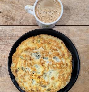 a pie in a pan next to a cup of coffee at Mosaic Hostel Varanasi in Varanasi +19 photos