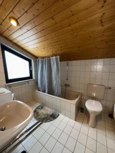 a bathroom with a toilet and a tub and a sink at Monteurzimmer Schäfer - Rhein Main in Hösbach