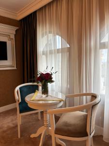 a table and two chairs with a vase of flowers at Cardinale Resort in Iaşi