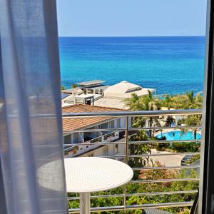 a view of the ocean from the balcony of a resort at Resort Rocca di Vadaro - Seafront Suites, Rooms & Apartments in Capo Vaticano