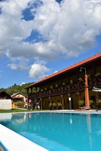 a large swimming pool in front of a building at Penzión na Ráztočnom in Klenovec